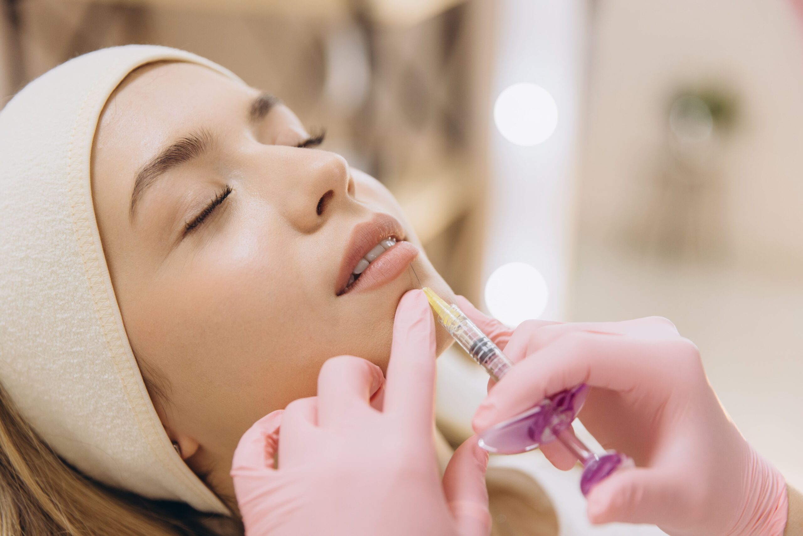 Doctor performing a lip injectable procedure on a patient in clinic