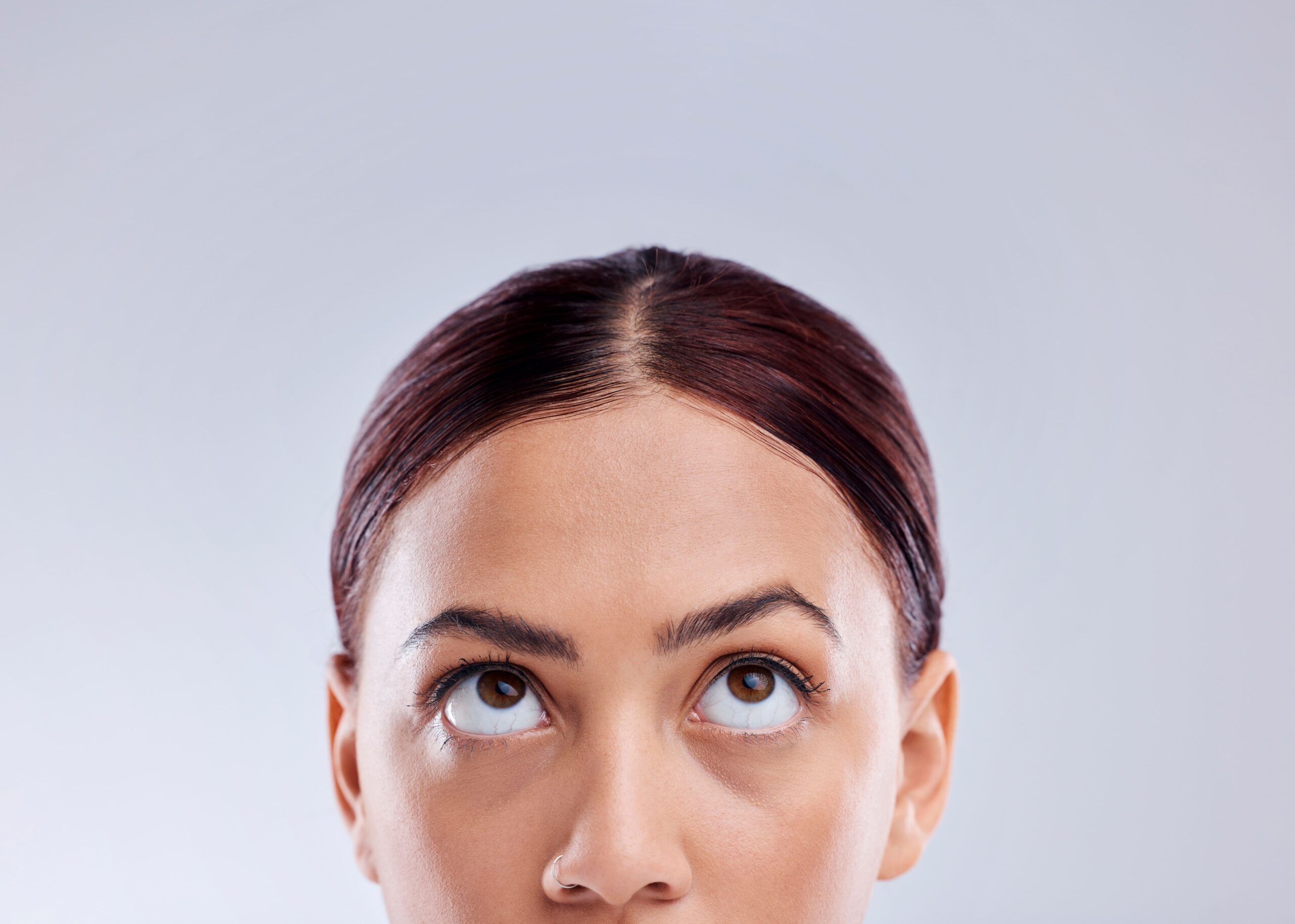 Lifestyle portrait of a woman looking upward with thoughtful expression