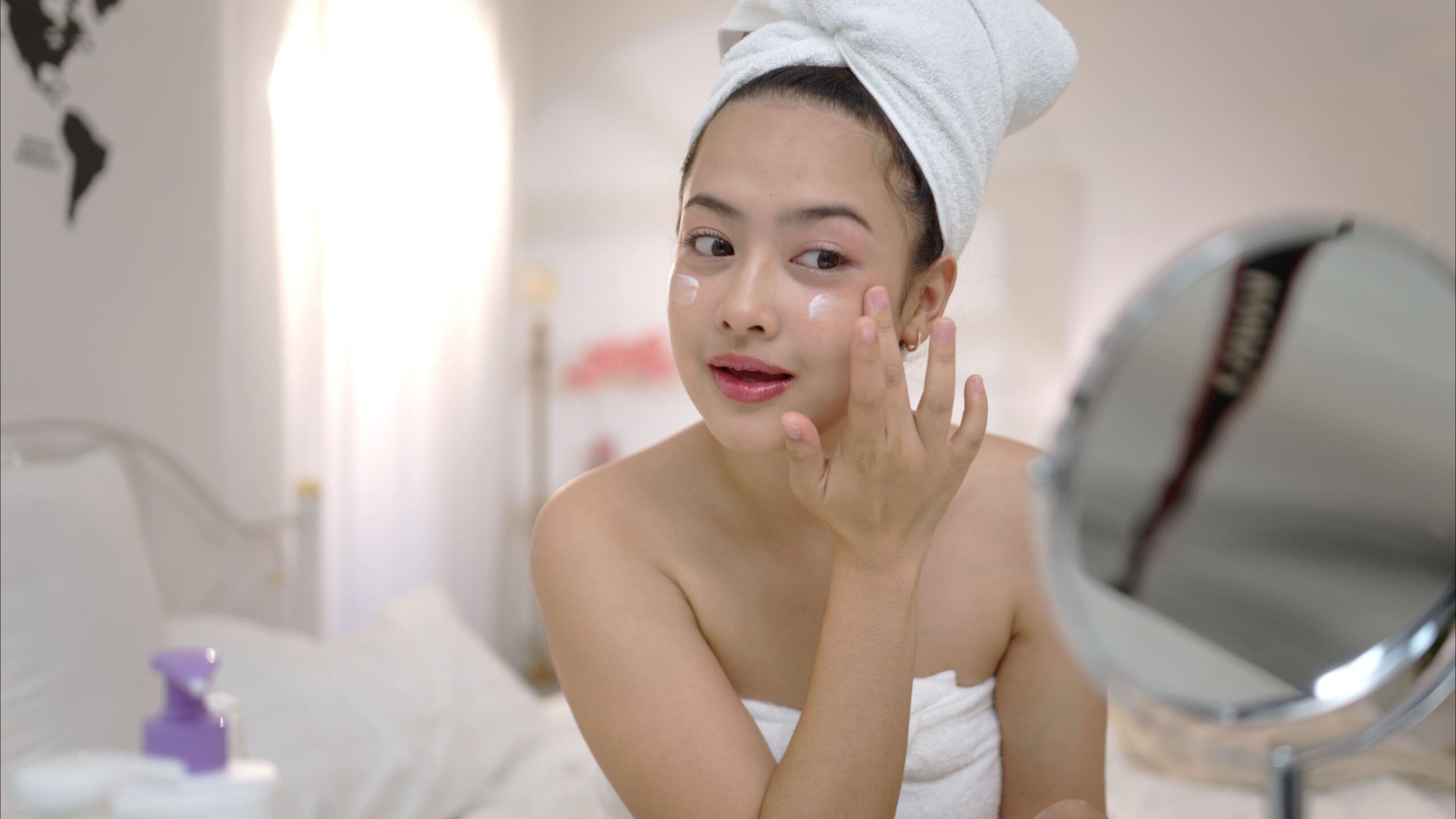 woman applying cream to face in bedroom 2026 03 16 22 58 47 utc 1 scaled