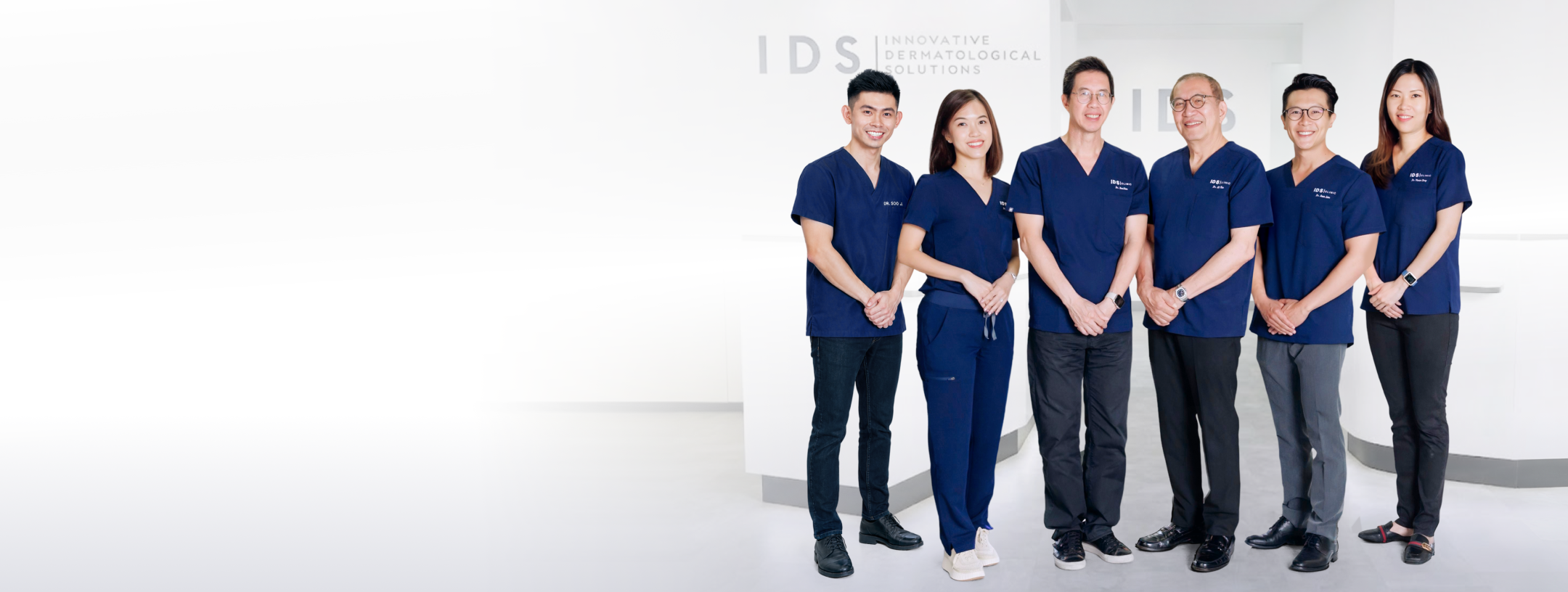 A group of five medical professionals in dark blue scrubs standing together in a clinic, showcasing a modern and professional environment.